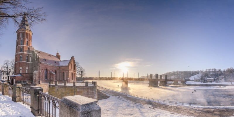 Kaunas winter scene with lots of snow on the ground overlooking a cathedral and the river in Lithuania 