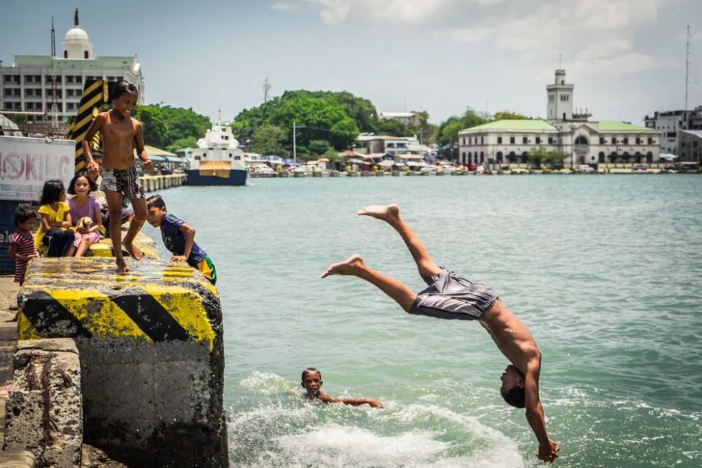 Filipino kids don’t need too much to have fun. These are jolly children at the port in Iloilo, Philippines on a hot sunny day.