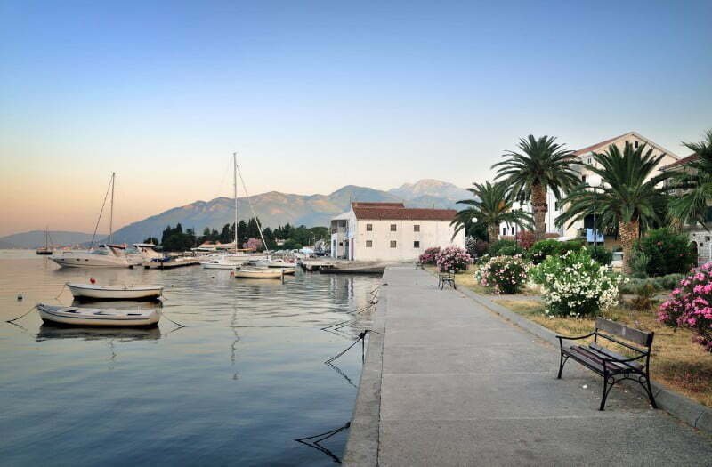 Tivat Travel Guide: Things to do in Tivat, Montenegro with views of the harbour boardwalk with sailboats on the water