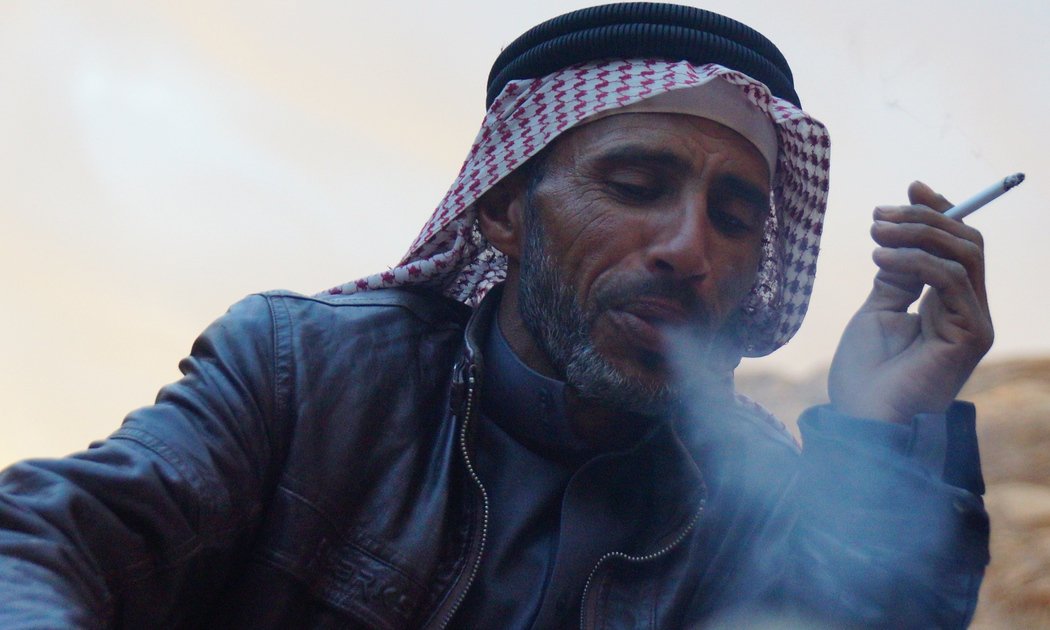 A Bedouin man puffs exhales smoke from a cigarette nearby our camp in Wadi Rum