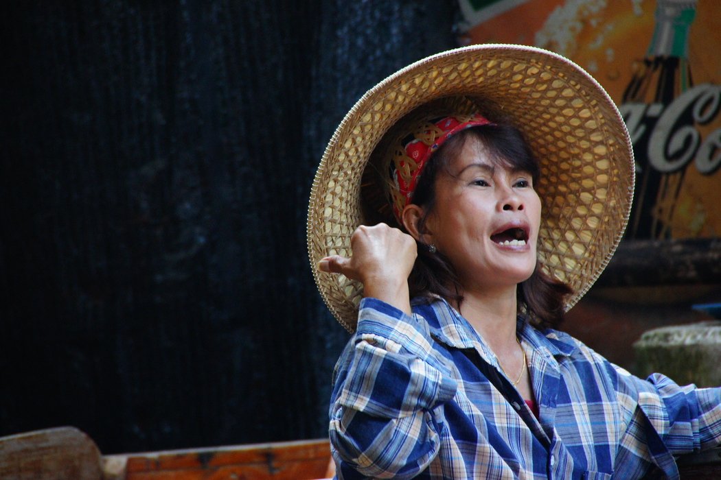 A candid moment, where this Thai lady is communicating with another vendor at the Damnoen Saduak Floating Market in Thailand 