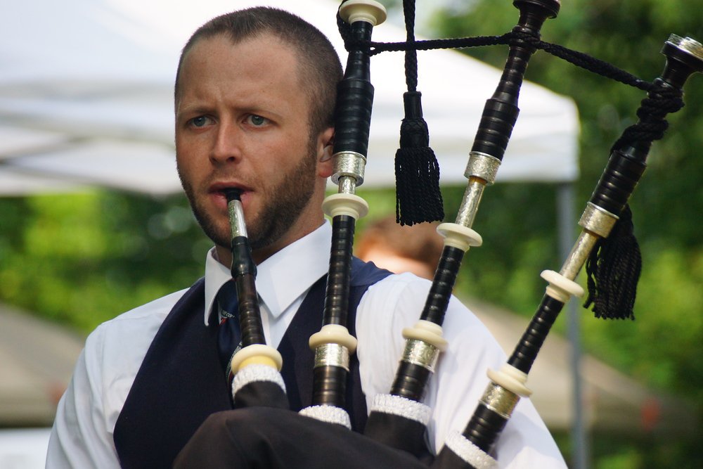 A close up shot of a man playing the bagpipes at the Highland Games