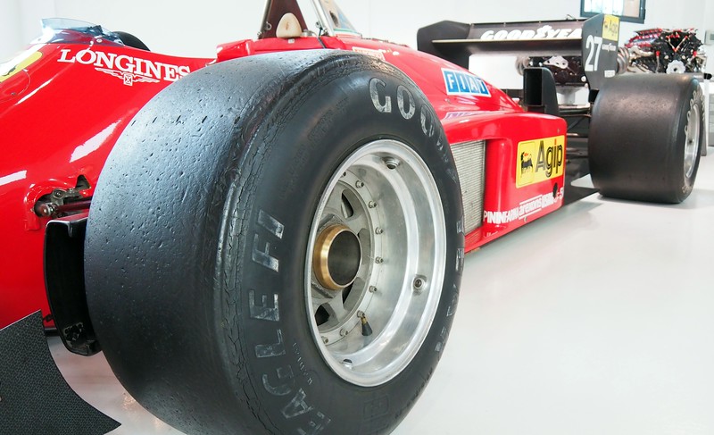 A close-up shot of one of the wheels of a racing car on display at the Enzo Ferrari Museum