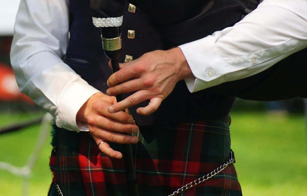 A close up shot of the hands of a talented bagpipe performer