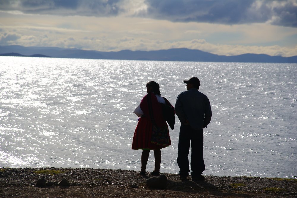 A couple look out over Lake Titicaca in the late afternoon in Peru 