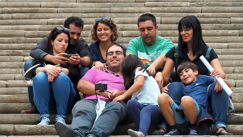 A family enjoying a selfie portrait on the steps of the cathedral in Girona