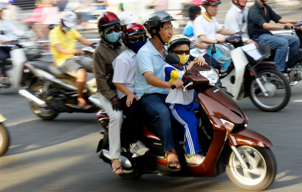 A family of four on a moped in Saigon, Vietnam is a typical transportation scene
