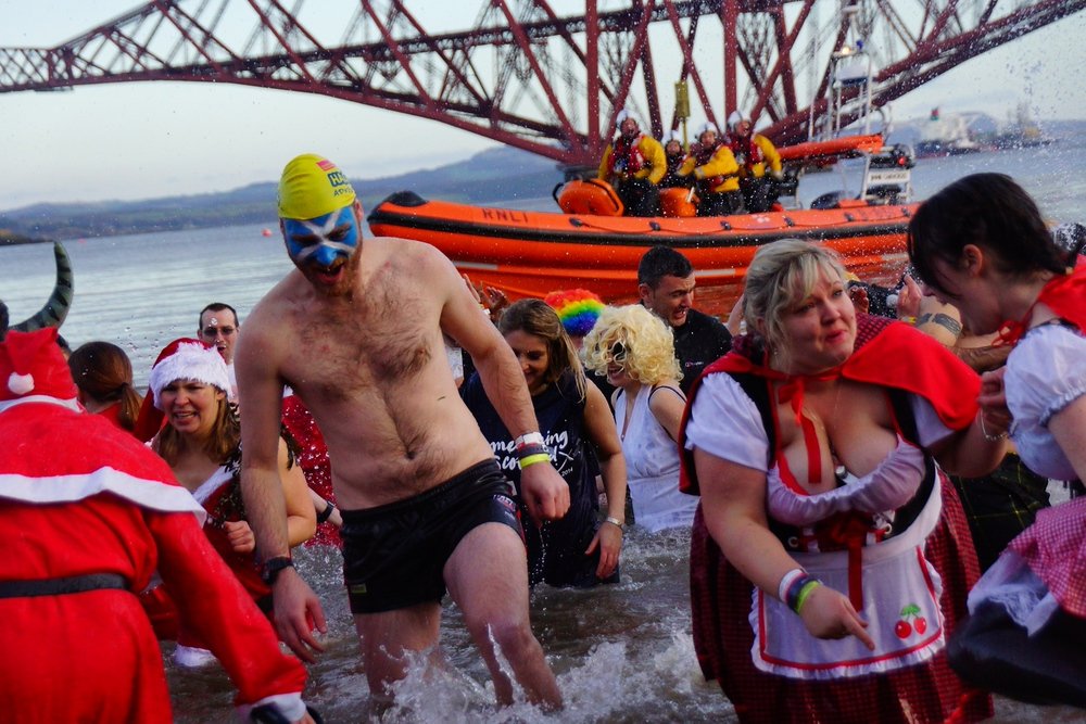 A group of mad souls brave the icy cold waters of the Firth of Forth to ring in the New Year