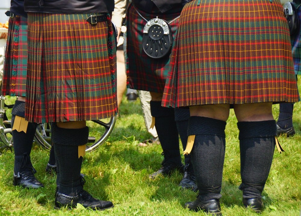 A group of men wearing kilts form in a circle to socialize at the New Brunswick Highland Games in Fredericton, Canada