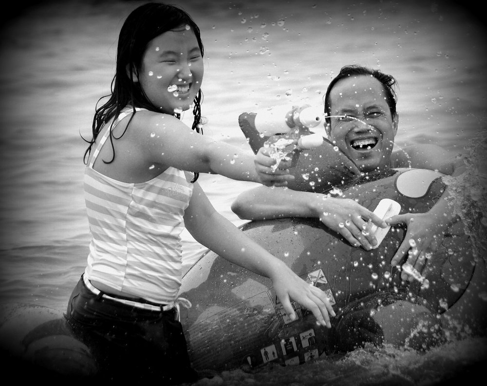 A Korean family enjoys a water gun fight with plenty of squirting and even more smiling faces at the Boryeong Mud Festival in South Korea