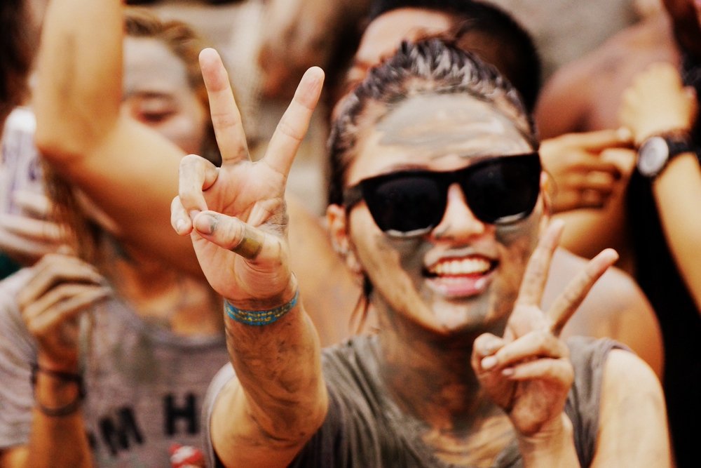 A Korean lady flashes a peace sign and an even bigger smile near the music stage at the Boryeong Mud Festival