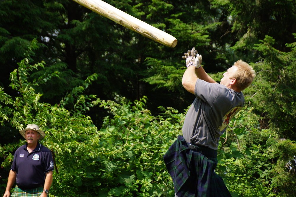 A man launching a caber into the air at the New Brunswick Highland Games in Fredericton Canada