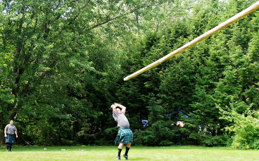 A man tossing a caber prior to it flipping over at the New Brunswick Highland Games