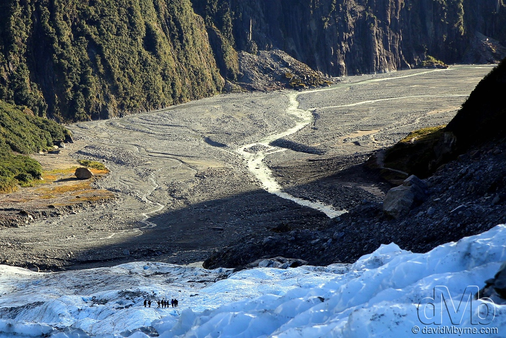 A party of climbers look very small as they descend Fox Glacier.