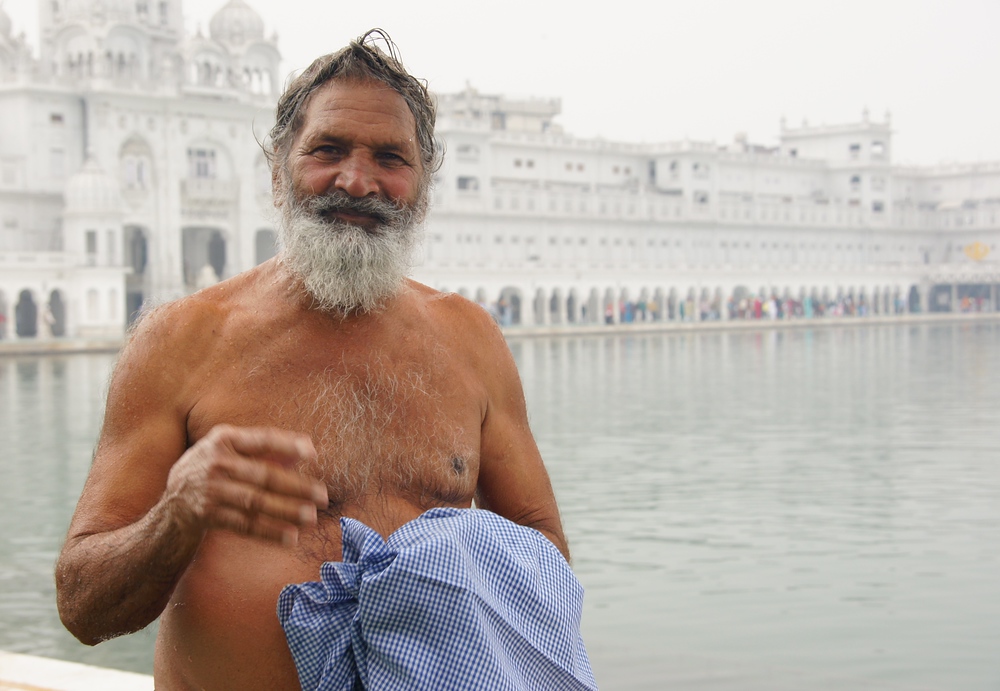 A photo of bare chested man with distinct smile and an impressive beard in Amritsar, Punjab, India 