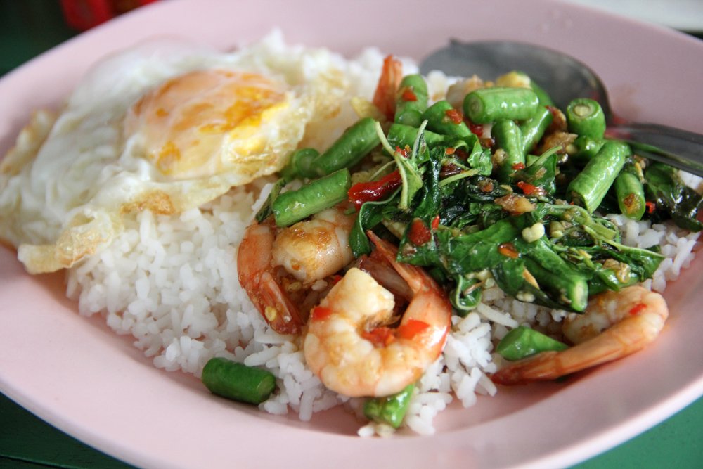 A photo of some normal Thai food with shrimp and greens and rice and egg