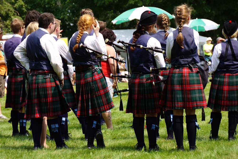 A piping and drumming band taking a rest on the field at the Fredericton Highland Games in New Brunswick, Canada 