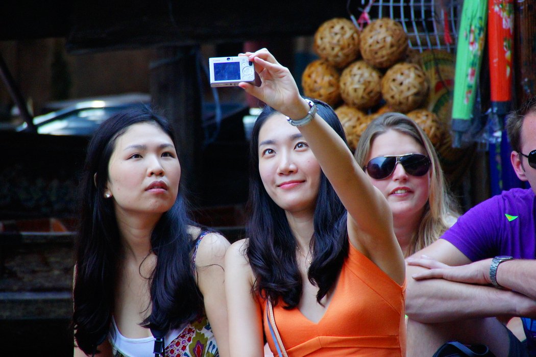 A selfie portrait from two tourists visiting the floating market in Thailand 