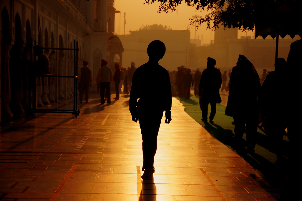 A silhouette shot of a man walking around during sunset in Amritsar