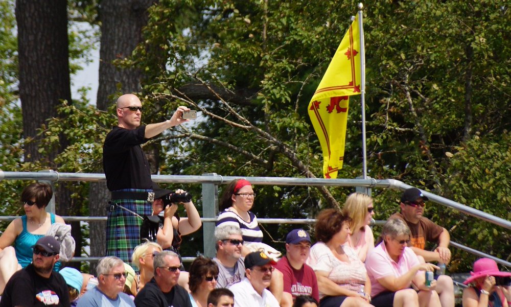 A spectator wearing a kilt snaps a photo at the Highland Games in Fredericton, New Brunswick