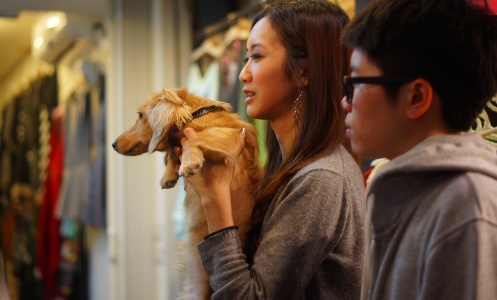 A Taiwanese lady holding her dog smiles in this photo at the Shilin Night Market in Taipei, Taiwan