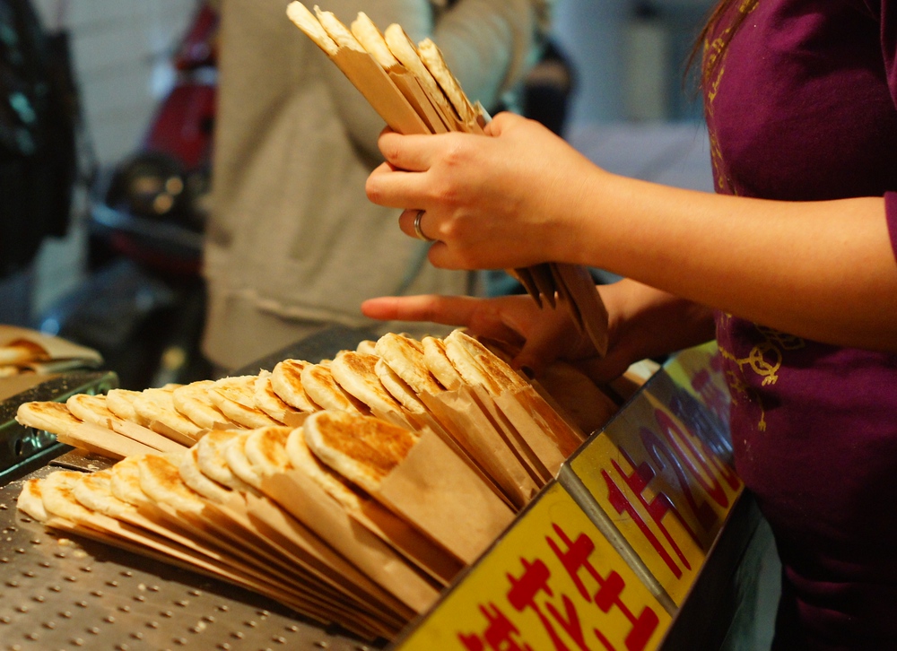 A Taiwanese vendor arranges hot cakes that are sold to the crowds passing by at night in Taipei, Taiwan