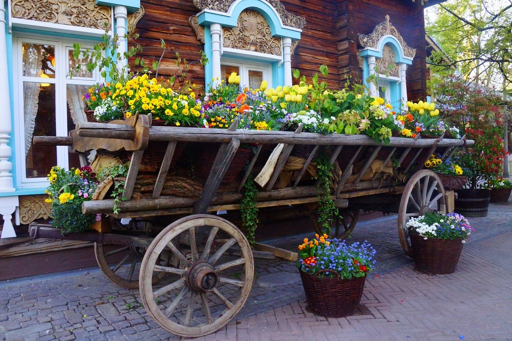 A traditional German wagon filled with a colorful display of potted flowers at Europa Park