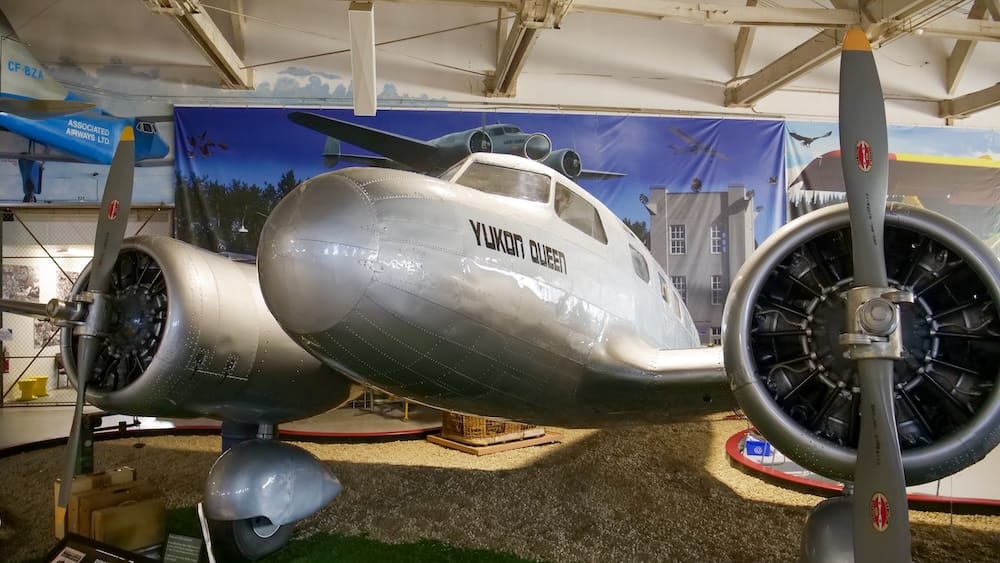 El avión clásico bimotor de color plateado pulido "Yukon Queen", con motores radiales y hélices a la vista, se exhibe dentro del hangar del Alberta Aviation Museum en Edmonton, Alberta, Canadá.