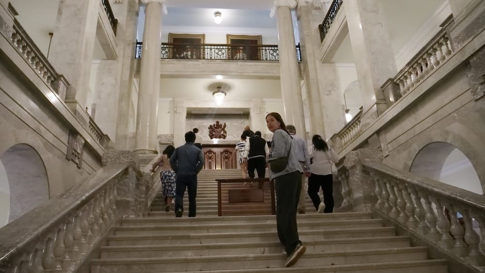 Audrey Bergner and guided tour group on the Alberta Legislature marble staircase in Edmonton, Alberta, Canada Audrey Bergner walks up the broad marble staircase inside the Alberta Legislature in Edmonton, Alberta, Canada, alongside other guided tour members beneath tall columns, galleries and ornate interior details.