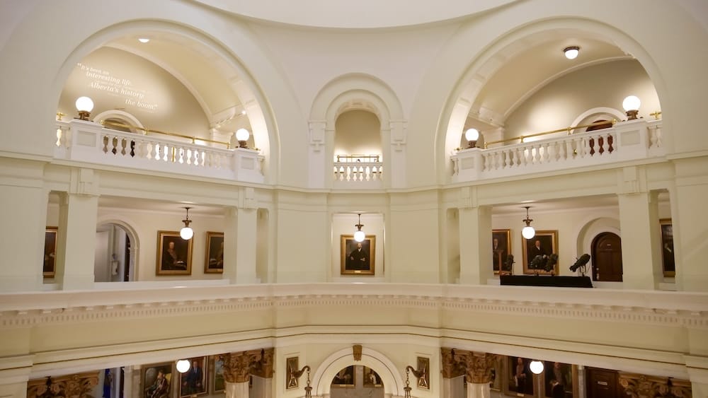 Alberta Legislature rotunda galleries with arches and portraits in Edmonton, Alberta, Canada Upper galleries inside the Alberta Legislature rotunda in Edmonton, Alberta, Canada, with large white arches, balustrades, hanging lights, framed portraits and classical architectural detailing.