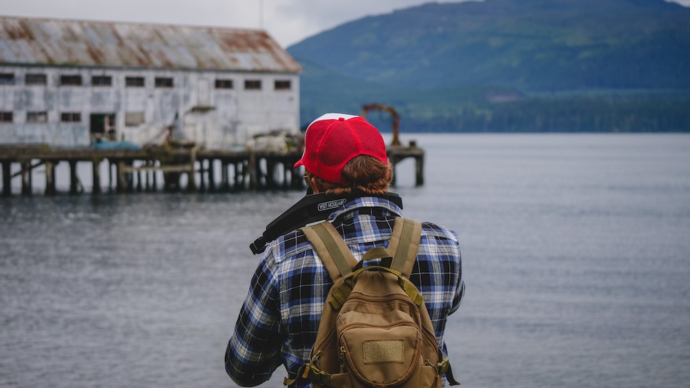 Nomadic Samuel Capturing Original Travel Photography in Alert Bay, British Columbia — Behind the Scenes Alert Bay, British Columbia — Nomadic Samuel photographing a historic waterfront scene with backpack and camera, capturing original travel photography and behind-the-scenes content for Nomadic Samuel destination guides, videos, and licensing use.