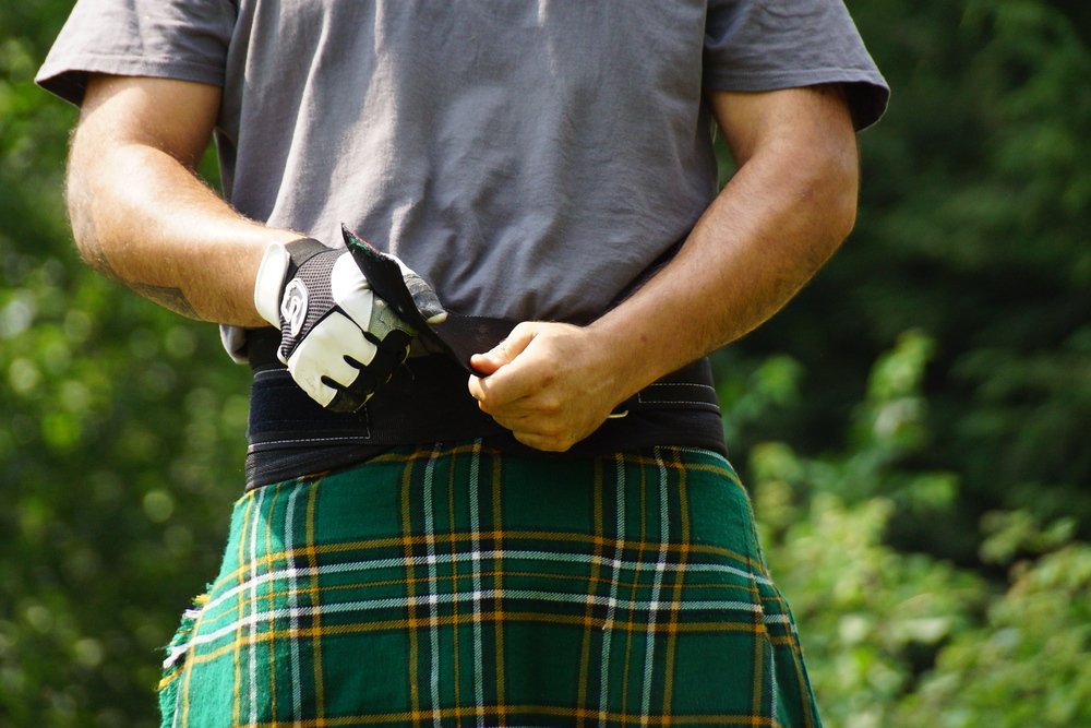 An athlete at the New Brunswick Highland Games adjust his kilt belt prior to a competition