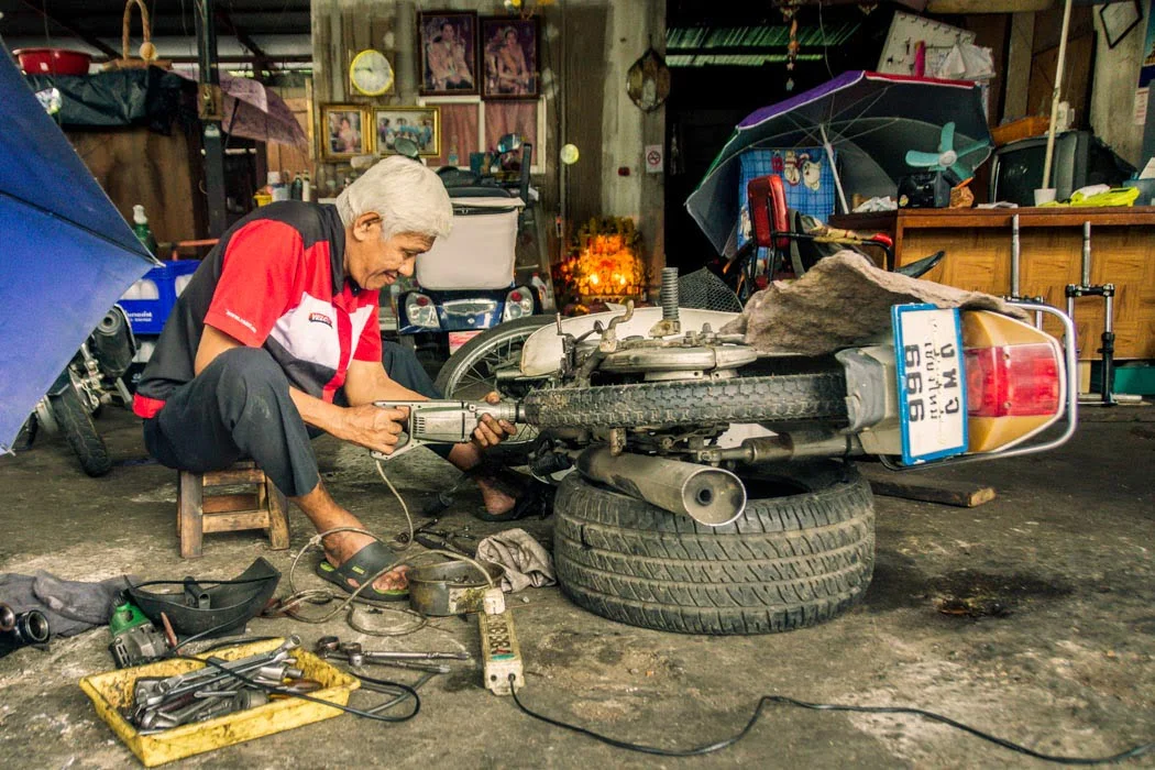 An intently focused mechanic in his workshop kingdom in Chiang Mai, Thailand, where everything’s in order.