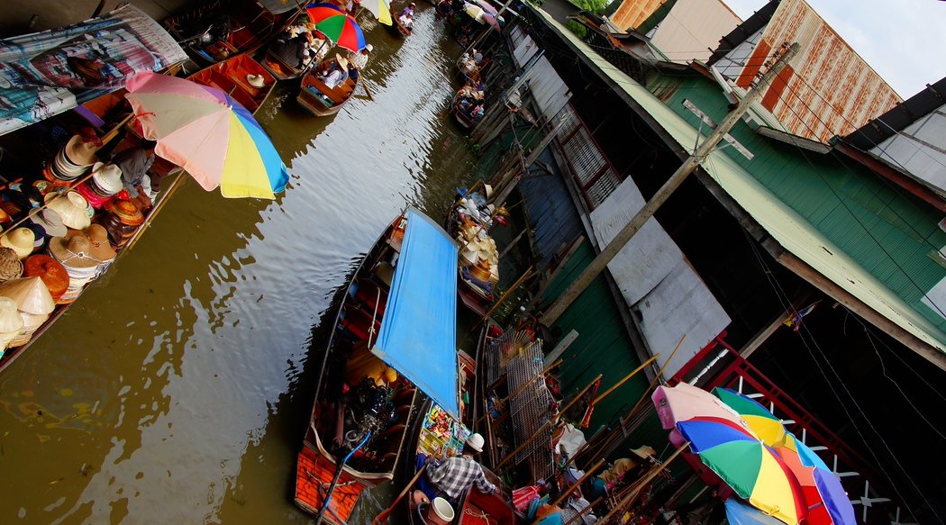 An overhead perspective shot of the colorful Damnoen Saduak Thai floating market 