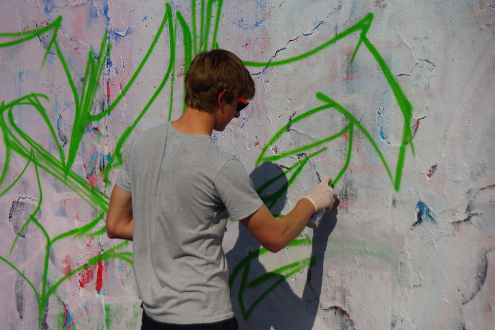 An urban street artist designing art on the wall of Mauerpark in Berlin, Germany 
