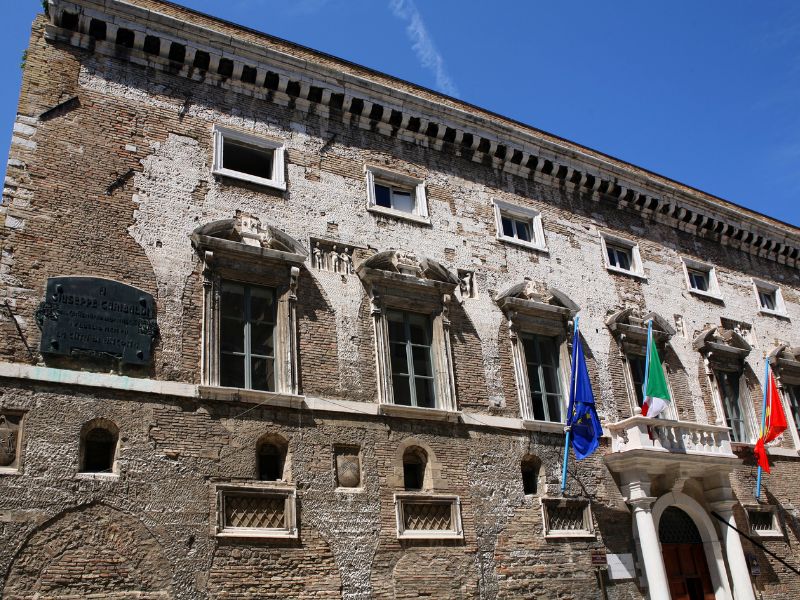 Ancona historic rustic building with flags 