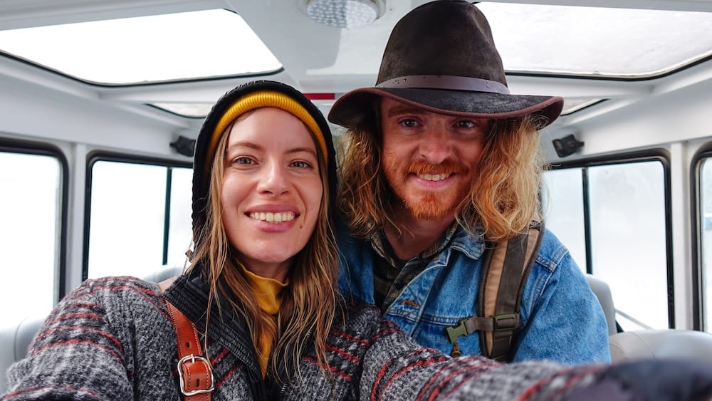 Audrey Bergner y Samuel Jeffery sonríen para una foto dentro de un Ice Explorer en Columbia Icefield, Alberta, Canadá, con ropa de abrigo después de viajar hacia el glaciar Athabasca.