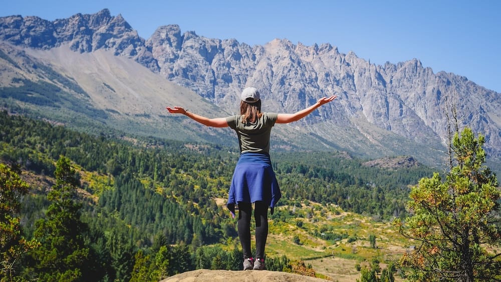 Audrey Bergner Overlooking the Andean Landscape of El Bolsón, Patagonia Audrey Bergner stands with her arms open toward the rugged Andean mountains above El Bolsón in Río Negro, northern Patagonia.