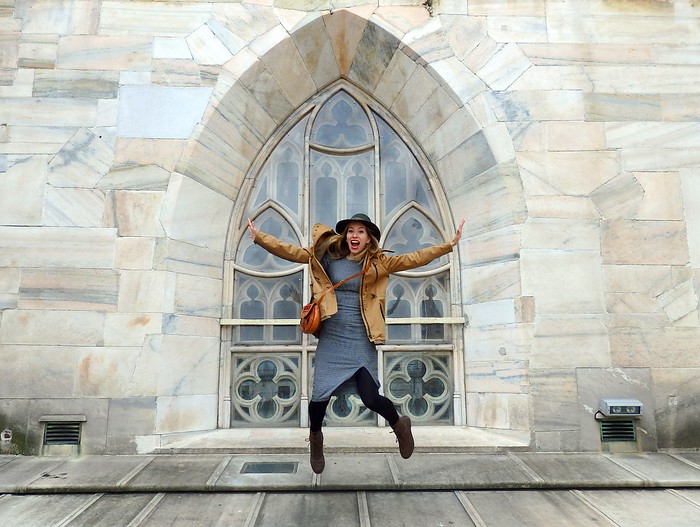 xAudrey Bergner of That Backpacker jumping in front of a window at Il Duomo in Milan, Italy