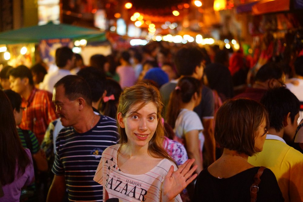The lovely Audrey Bergner of That Backpacker poses for a crowd perspective night shot during the busiest of times in Melaka, Malaysia