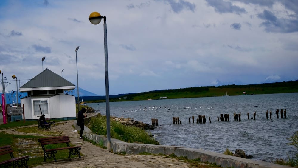 Audrey Bergner photographs the windswept Última Esperanza waterfront in Puerto Natales, Chile, a Patagonian gateway where weather, transport and route pivots shape the travel day.
