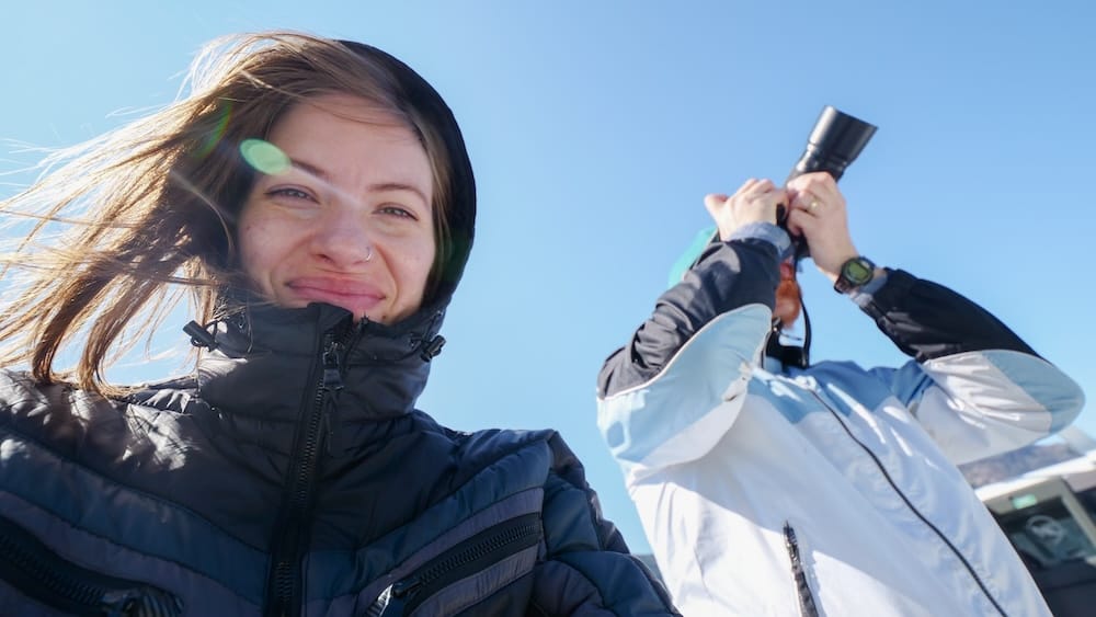 Audrey Bergner sonríe a cámara mientras Samuel Jeffery fotografía el paisaje glaciar durante una excursión en barco desde El Calafate, provincia de Santa Cruz, Patagonia argentina.