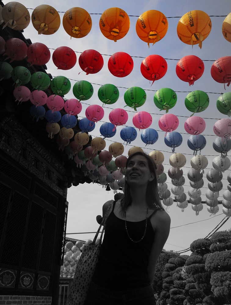Audrey Bergner (That Backpacker) hovering over a series of Buddhist lanterns in South Korea