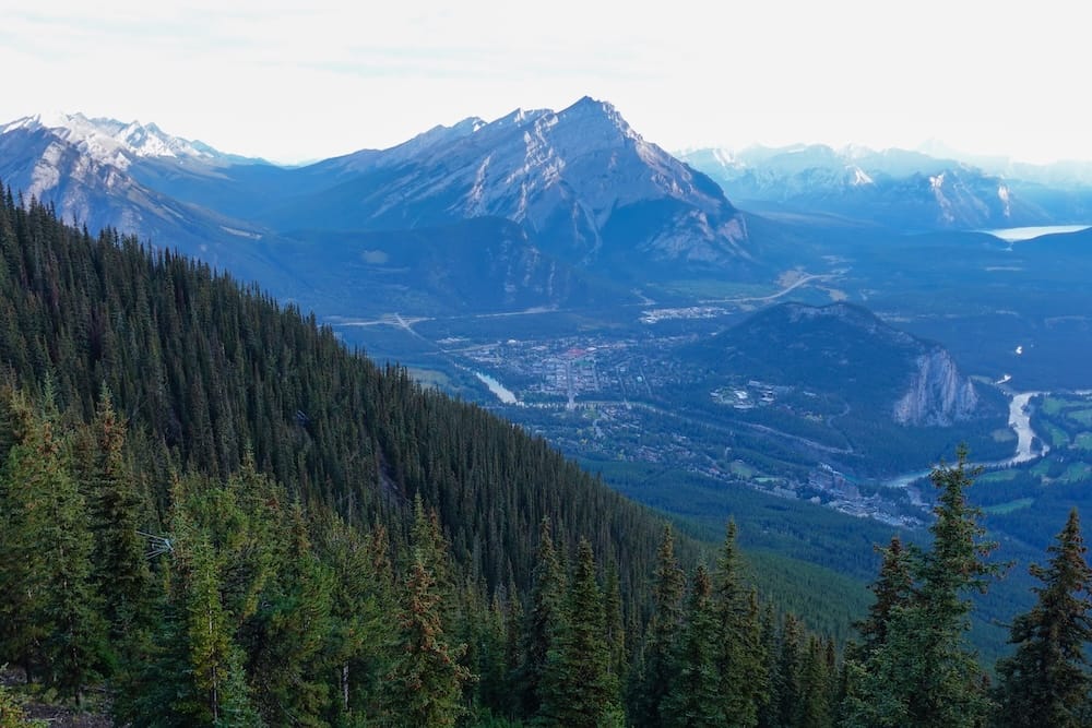 Banff townsite and Bow Valley seen from the Banff Gondola summit, Sulphur Mountain, Alberta, Canada The town of Banff sits in the Bow Valley far below, framed by forested slopes and surrounding mountain ranges, as seen from the Banff Gondola summit on Sulphur Mountain, Alberta, Canada.