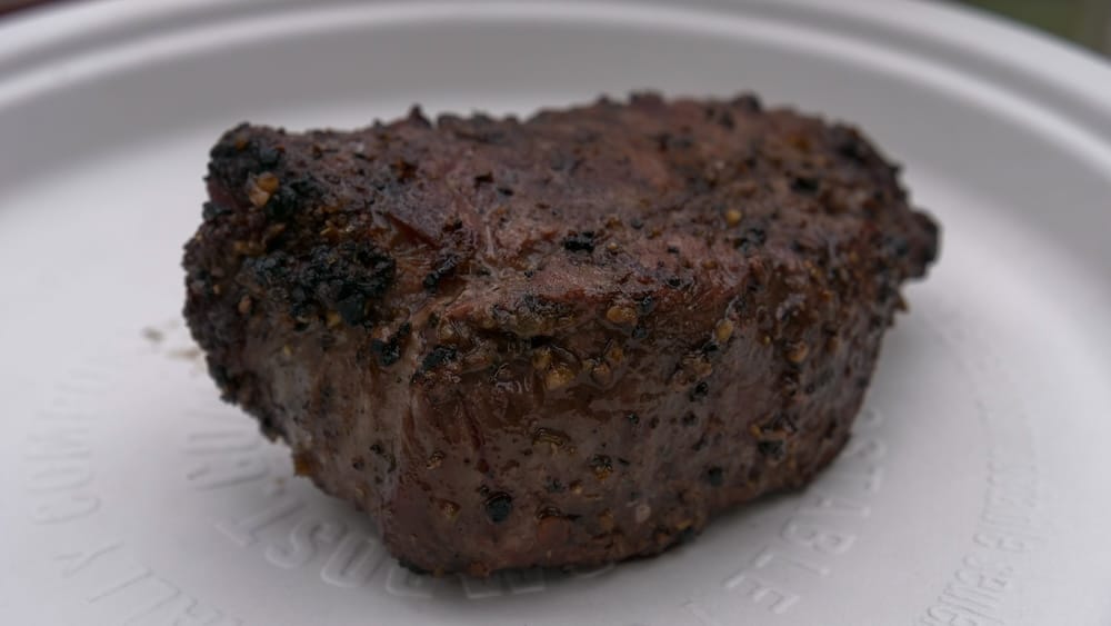 Bife a la parrilla durante un almuerzo de Banff Trail Riders en el Parque Nacional Banff, Alberta, Canadá Un bife grueso a la parrilla, con costra dorada y pimienta, descansa sobre un plato blanco durante un almuerzo de Banff Trail Riders en el Parque Nacional Banff, Alberta, Canadá.