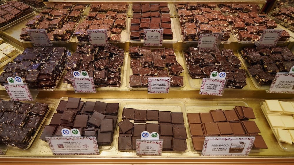 Assorted artisanal chocolates displayed in a shop in San Carlos de Bariloche including dark, milk, and nut-studded varieties, highlighting the city’s reputation as Patagonia’s chocolate capital with rows of handcrafted bars and regional flavors

