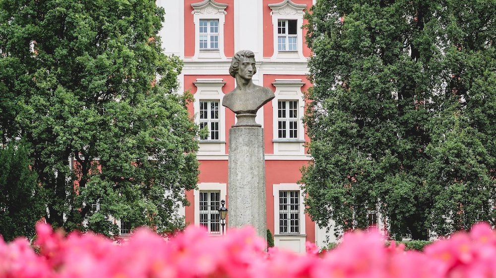 Beautifully framed bust and statue with flowers and greenery at Frederic Chopin Park in Poznan, Poland