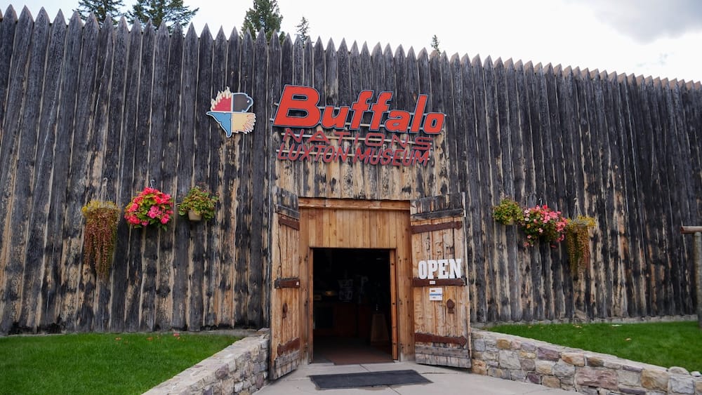 Buffalo Nations Museum Entrance in Banff, Alberta, Canada, with Historic Buffalo Nations Luxton Museum Sign Wooden entrance to Buffalo Nations Museum in Banff, Alberta, Canada, with pointed timber walls, hanging flower baskets and the older Buffalo Nations Luxton Museum name visible above the doorway.