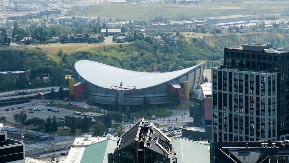 Calgary Saddledome visto desde la plataforma de observación de Calgary Tower en Calgary, Alberta, Canadá Vista desde la plataforma de observación de Calgary Tower en Calgary, Alberta, Canadá, hacia el Calgary Saddledome, con edificios, calles y la ladera verde detrás del estadio.