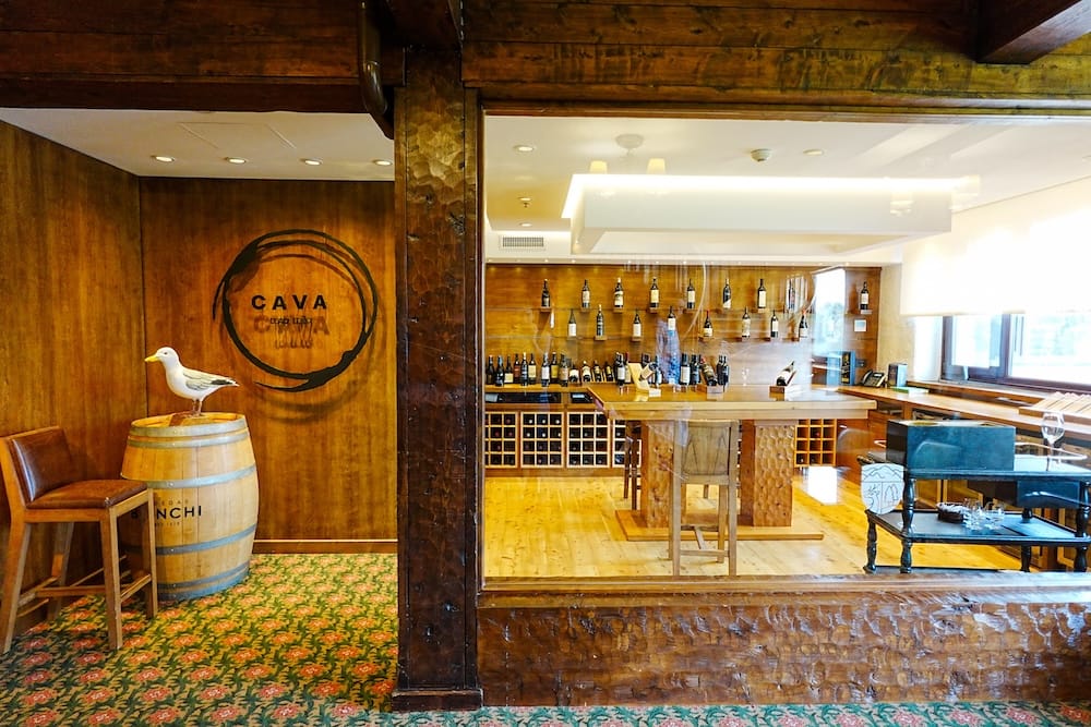 Cava Llao Llao Wine Cellar Interior at Llao Llao Hotel, Bariloche, Río Negro, Patagonia, Argentina Cava Llao Llao wine cellar at Llao Llao Hotel in Bariloche, Río Negro, Patagonia, Argentina, with rustic wood walls, a barrel display, bottle-lined shelves, tasting tables and warm interior lighting.